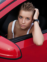Fascinating teen girl undressing and showing attractive slim body outdoors near red opel.