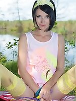 Stunning skinny teen plays around with her body on the lap of nature with the blue sky complimenting her beauty.