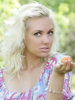 Perfect blonde teen girl with a basket of peaches taking off clothes and spreading outdoors.