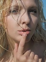 Blonde babe enjoying the sunshine on the beach as it burns all of her naked body and flawless boobs.