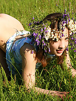Alluring cutie wearing a garland of flowers shows off her most intimate parts in the field.