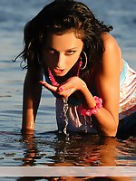 The stylish brunette in blue plays artistically and shows her body on the big river.