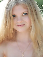 Gorgeous long haired blonde teen girl taking off dress and posing naked on the beach.