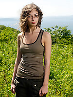 This cheeky good-looking honey is standing in the field with a brown horse and rubs against this wonderful animal.