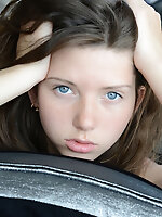 Gorgeous long haired busty shapely teen cutie posing in only a sexy stocking on the sofa.