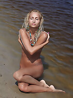 Afina flaunts her petite yet magnificently toned body with tight and firm assets as she sprawls on the sandy shore of the lake.