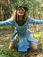 This image set is about a gorgeous blonde teen who takes off her blue dress to do a stirring tease show in the woods.